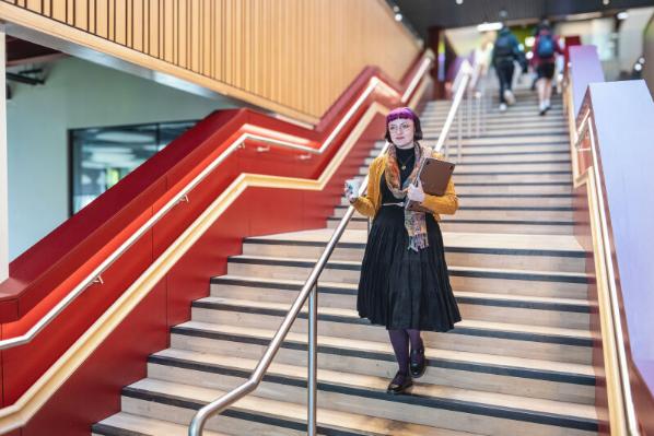 Emma Houston walking downstairs in the One Elmwood building